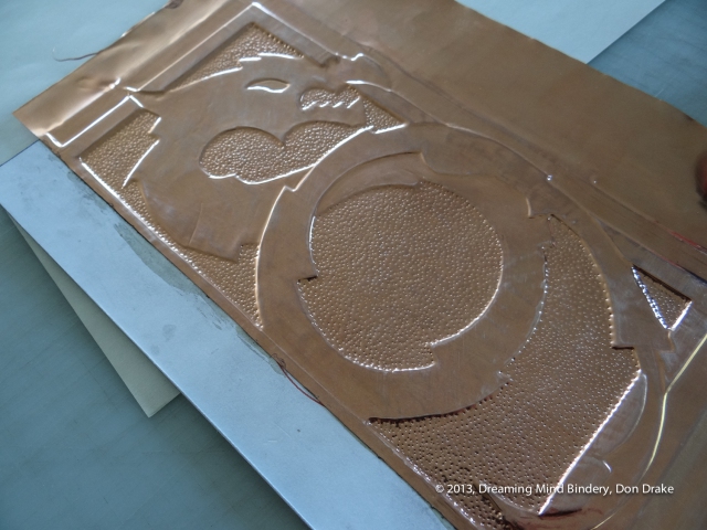 Adding texture and detail to the debossed copper on a copper journal cover