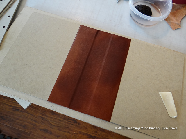 Brown leather pasted down on the cover of a quarter bound notebook