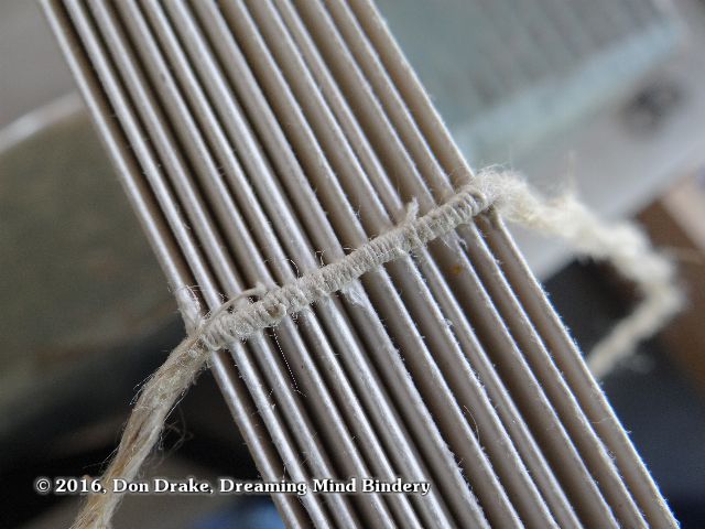 Detail of thread wrapping around a sewing cord