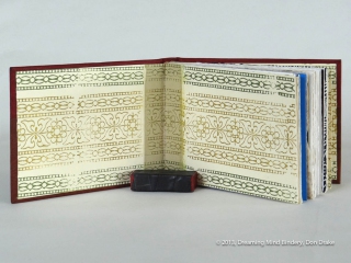 An interior view of Don Drake's binding of the Bay Area Book Artists' (BABA) collaborative project, AlphaBeastiary, showing the block printed endpapers he created for the project.